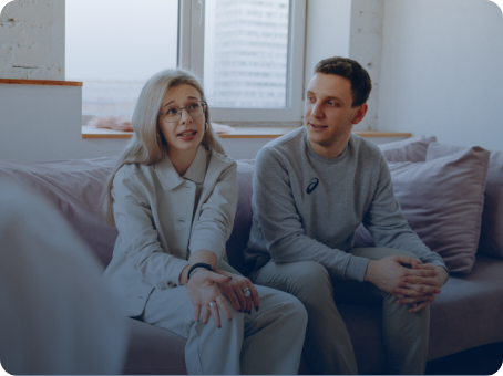 A man and woman sitting on top of a couch.