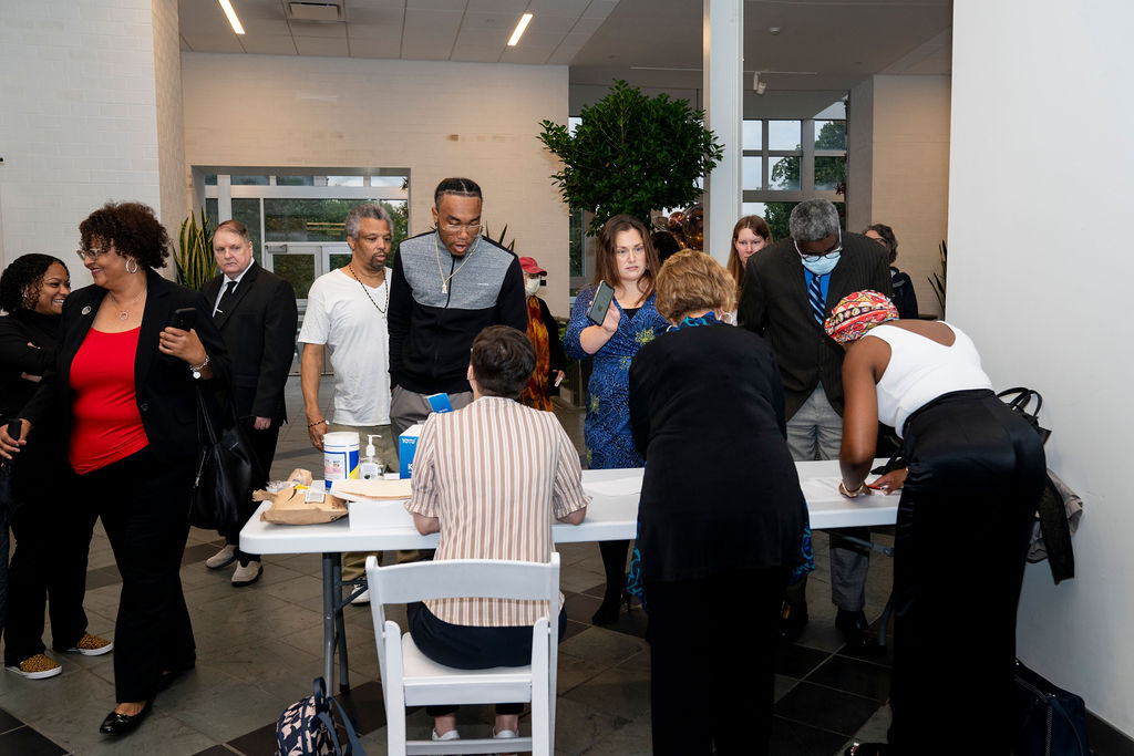 A group of people standing around a table.