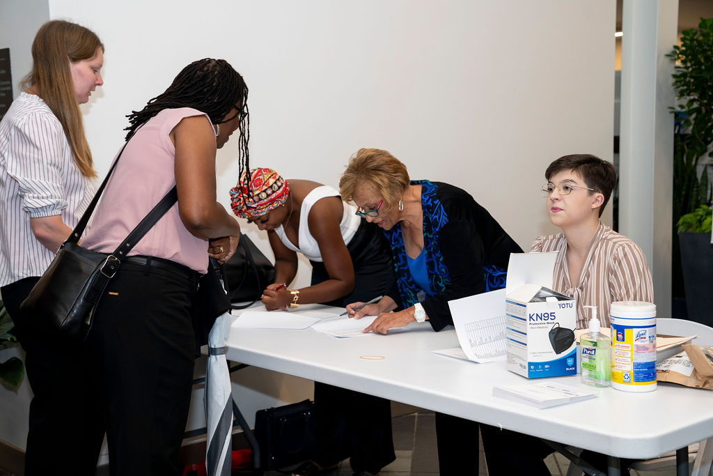 A group of people sitting at a table signing books.