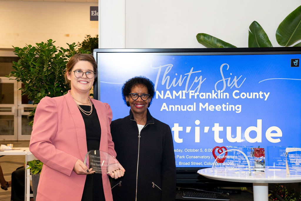 Two women standing next to each other holding a plaque.