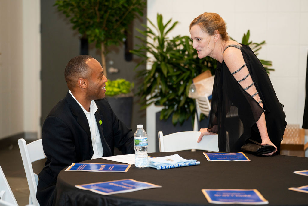 A man and woman sitting at a table talking.