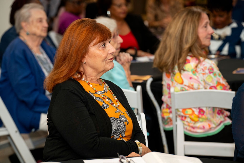A woman sitting in front of other people.